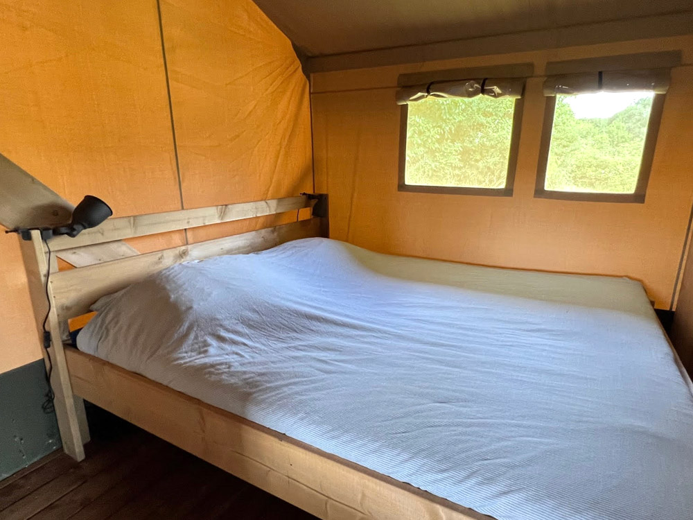 Slaapkamer met een tweepersoonsbed in safaritent